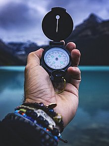 Am ausgestreckten Arm ist in der Hand ein Kompass zu sehen, der die Richtung weisen sollen.