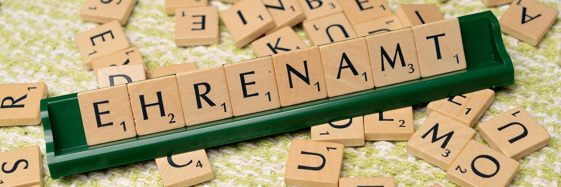 Das Wort "Ehrenamt" zusammengesetzt aus den Buchstabenklötzchen eines Scrabbel-Spiels