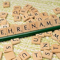 Das Wort "Ehrenamt" zusammengesetzt aus den Buchstabenklötzchen eines Scrabbel-Spiels
